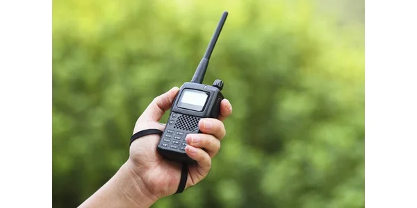 Someone holding a two-way radio (or walkie-talkie).