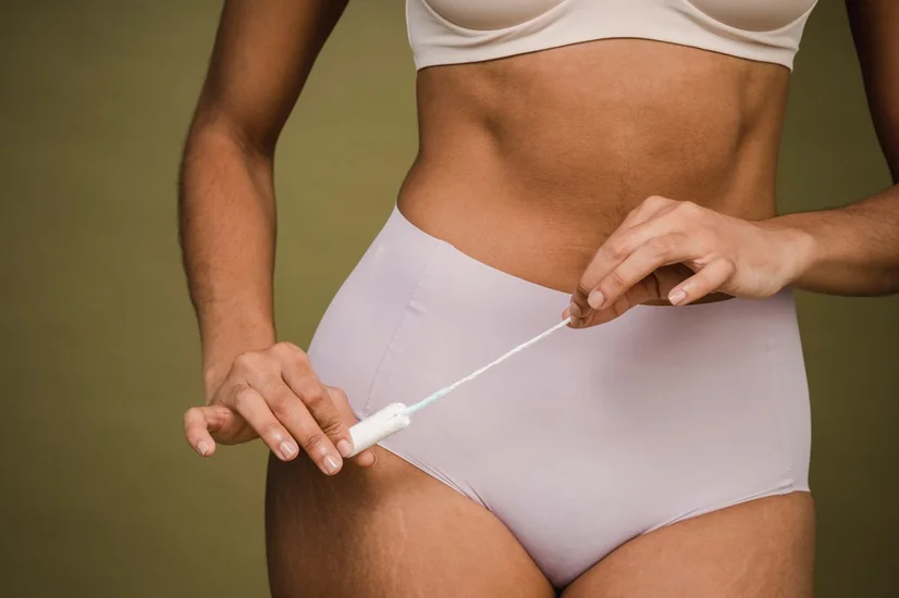 Woman in underwear holding a tampon