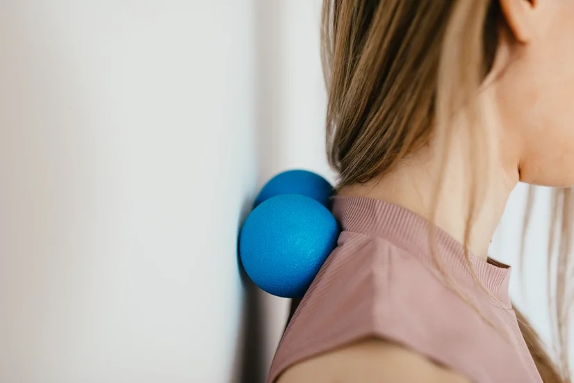 Woman using foam roller against her neck