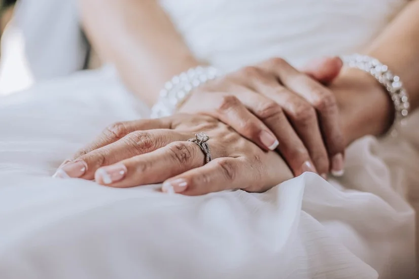 A bride wearing a diamond wedding ring on her finger.