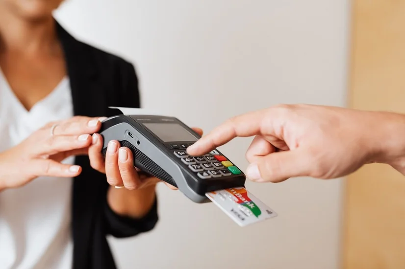 A man entering his pin on an EFTPOS machine to make a purchase with his credit card.