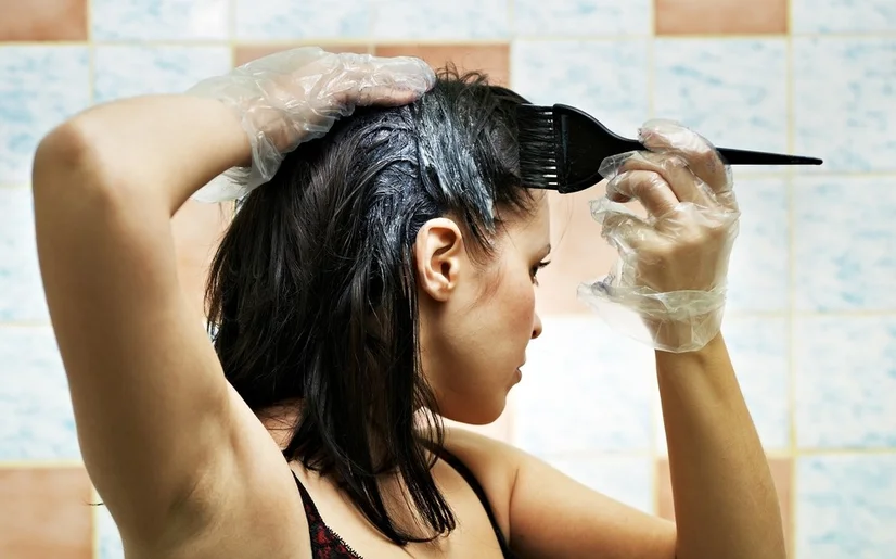 A woman dyeing her hair at home.