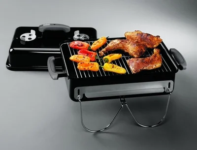the weber go anywhere charcoal barbeque with cooked thighs and capsicums