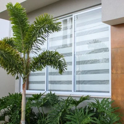 A view from the exterior of a home where zebra blinds are used in the front window.