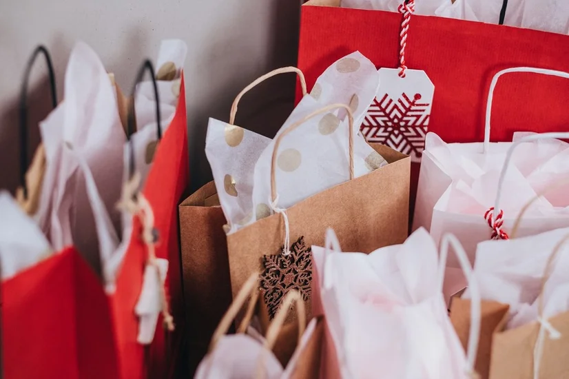 A close up of red and brown paper bags containing Christmas gifts.