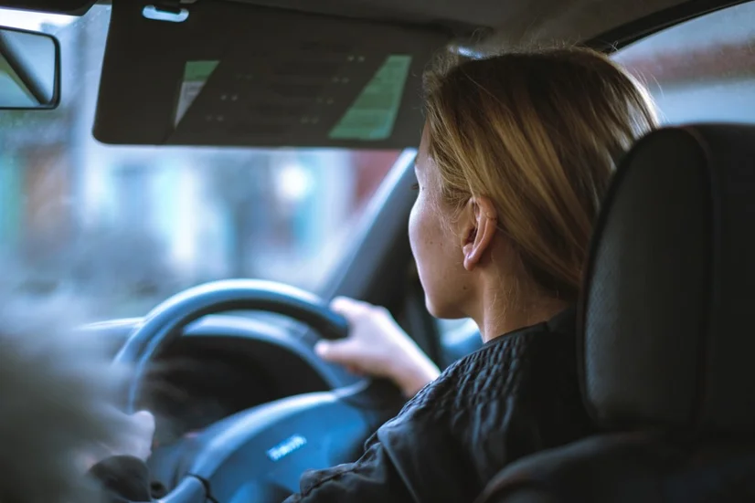 A blonde woman driving a car.