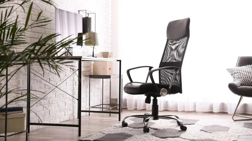 A black office chair in a brightly lit office.