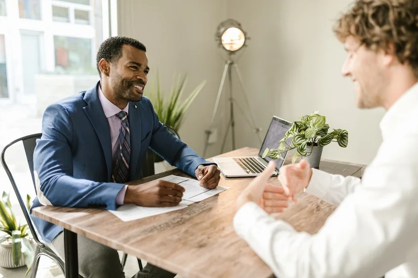 Two men sitting at a table and talking business.