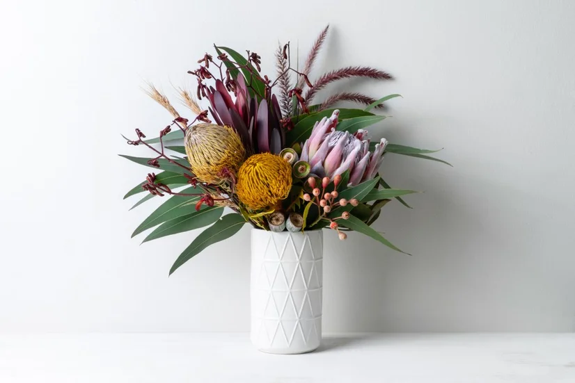 Bright native floral arrangement in geometric white vase