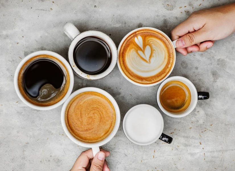A birds eye view of 6 cups of coffee - including a latte, espresso and long black - on a table.