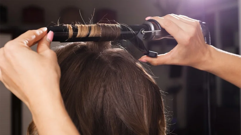 Section of hair wrapped around hair curling tongs