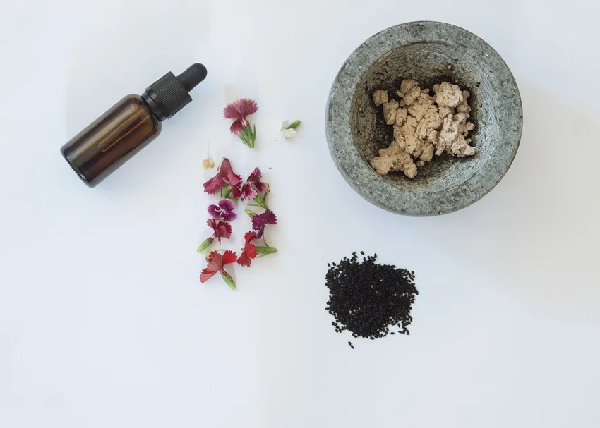 serum, flowers and other natural skincare products arranged neatly