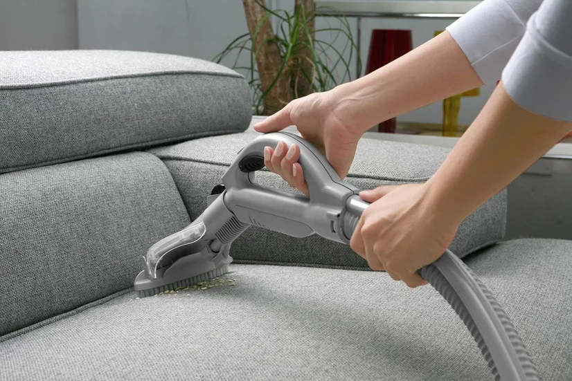 Couch being cleaned with specialised upholstery attachment