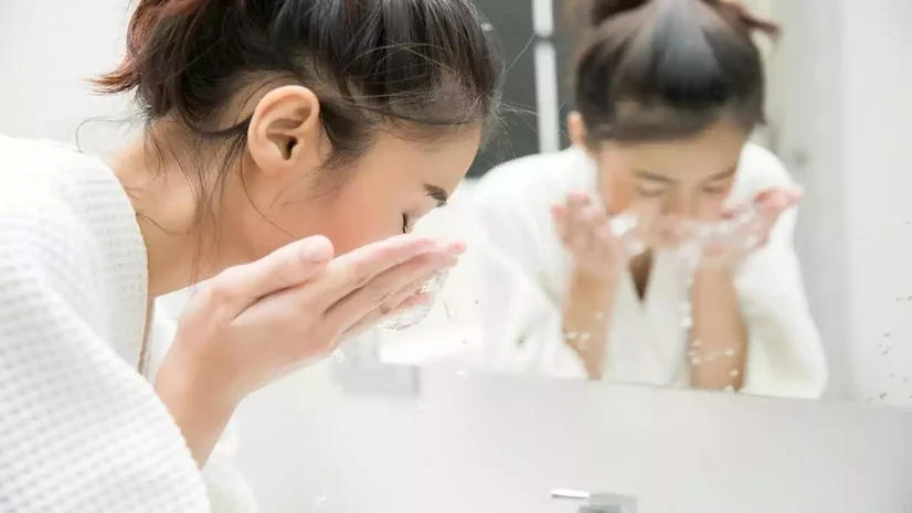 Woman washing her face in the sink