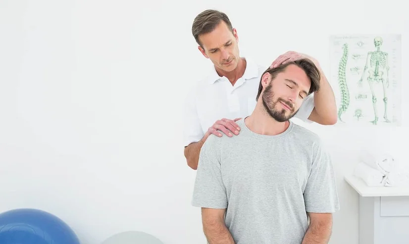 Man looking relaxed as a chiropractor releases tension in his head and neck
