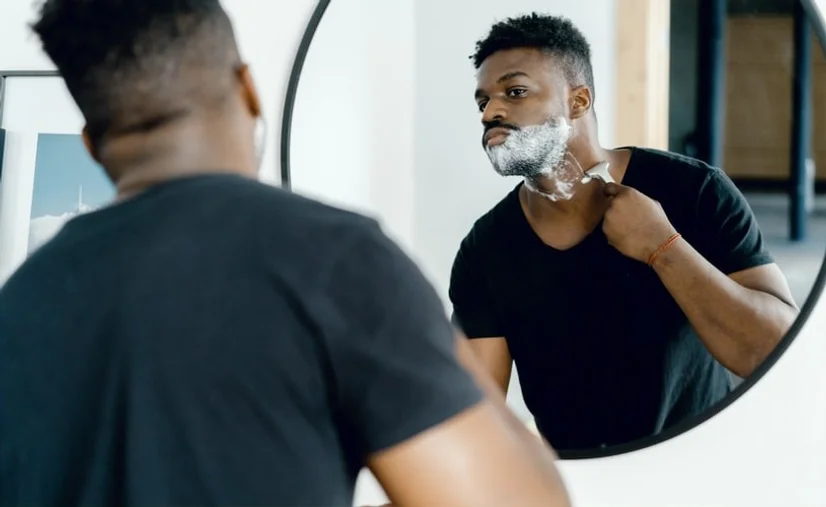Man shaving his neck in front of the mirror
