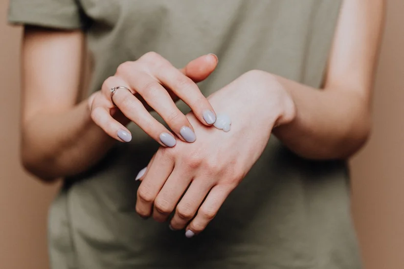 Woman with moisturiser on hand
